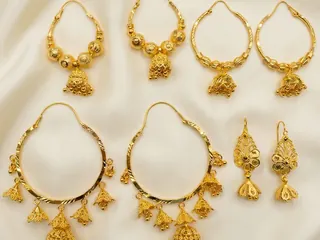 Hoops & Drops — Bin Maqsood gold hoop and drop earrings arranged neatly on ivory silk.