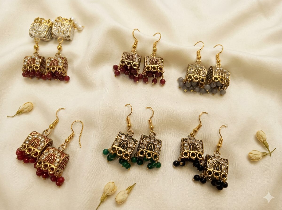 Bin Maqsood traditional coloured jhumka earrings arranged on ivory silk.