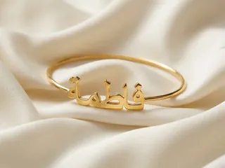 Name Bracelets & Bangles — Bin Maqsood Arabic script Fatima name bangle on ivory silk.