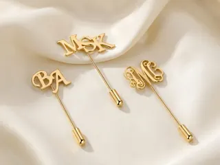 Pins & Cufflinks — Bin Maqsood gold initial lapel pins on ivory silk.